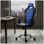 Blue and black ergonomic office chair with armrests in a home office, beside a wooden desk and a window with a city view