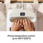 Close-up of hands pressing a white temperature-control panel; digital screen shows 400°F (205°C).