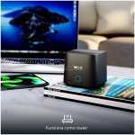 Small black wireless router on a desk beside a laptop and a smartphone, illustrating home networking.