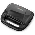 Black+Decker compact electric sandwich press with a clamshell lid and integrated handle for toasting sandwiches.