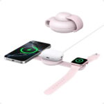 Pink magnetic wireless charging dock holding a round earbuds case, with an iPhone and Apple Watch also charging nearby.