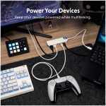 Desk setup showing a USB power hub with cables, a white game controller, keyboard, and laptop.