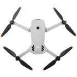 Top-down view of a white DJI quadcopter drone with four propellers and orange tips on the blades