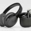 Maxell wireless over-ear headphones with a matching black charging case and earbuds nearby